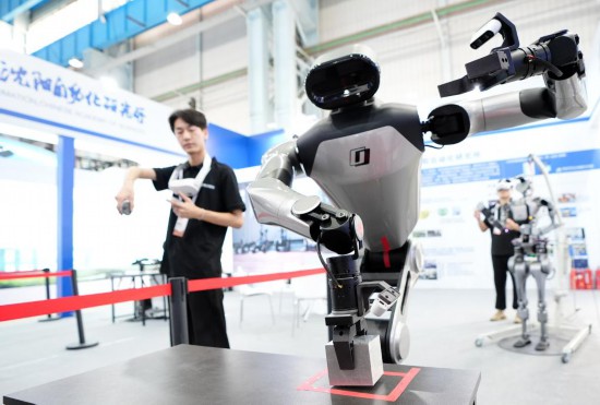 9月5日，在沈陽(yáng)的2025全球工業(yè)互聯(lián)網(wǎng)大會(huì)的展覽區(qū)現(xiàn)場(chǎng)，中國(guó)科學(xué)院沈陽(yáng)自動(dòng)化研究所的機(jī)器人工程師在調(diào)試具身智能操作系統(tǒng)。新華社記者 李鋼 攝